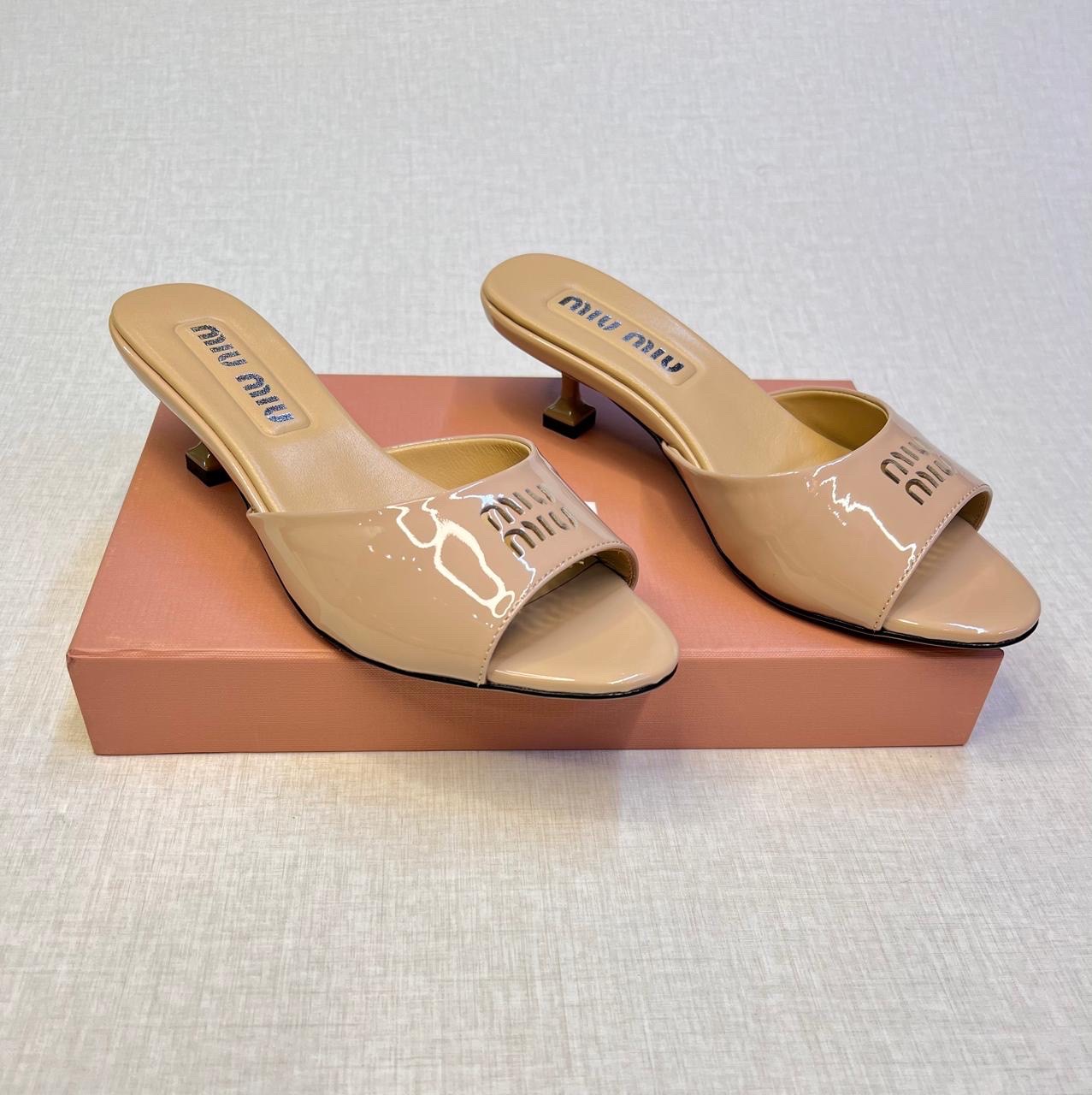 Miu Miu patent leather slides in beige with an almond-shaped toe and a low heel image 1