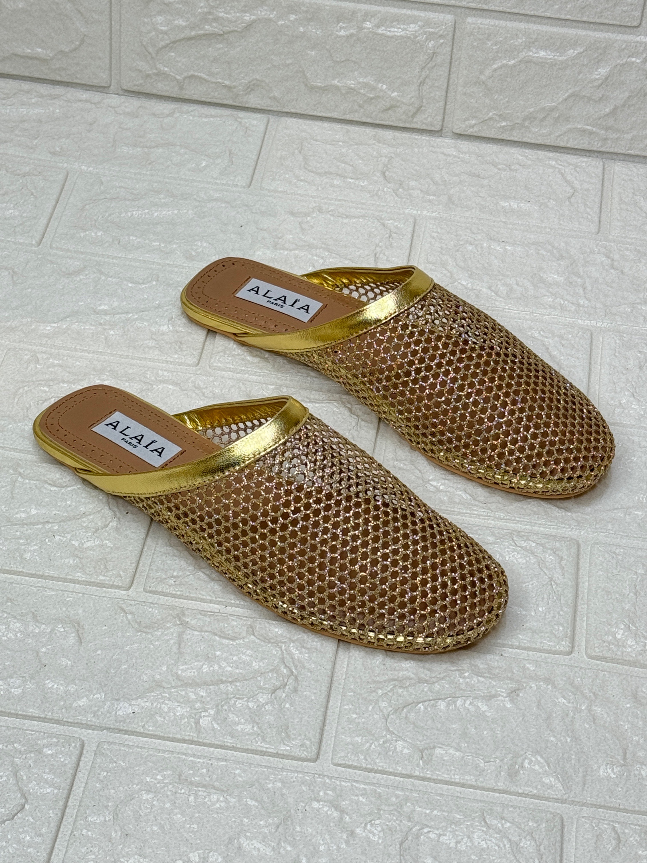 Alaïa Infradito fishnet mesh mules in gold with metallic leather trim. image 1