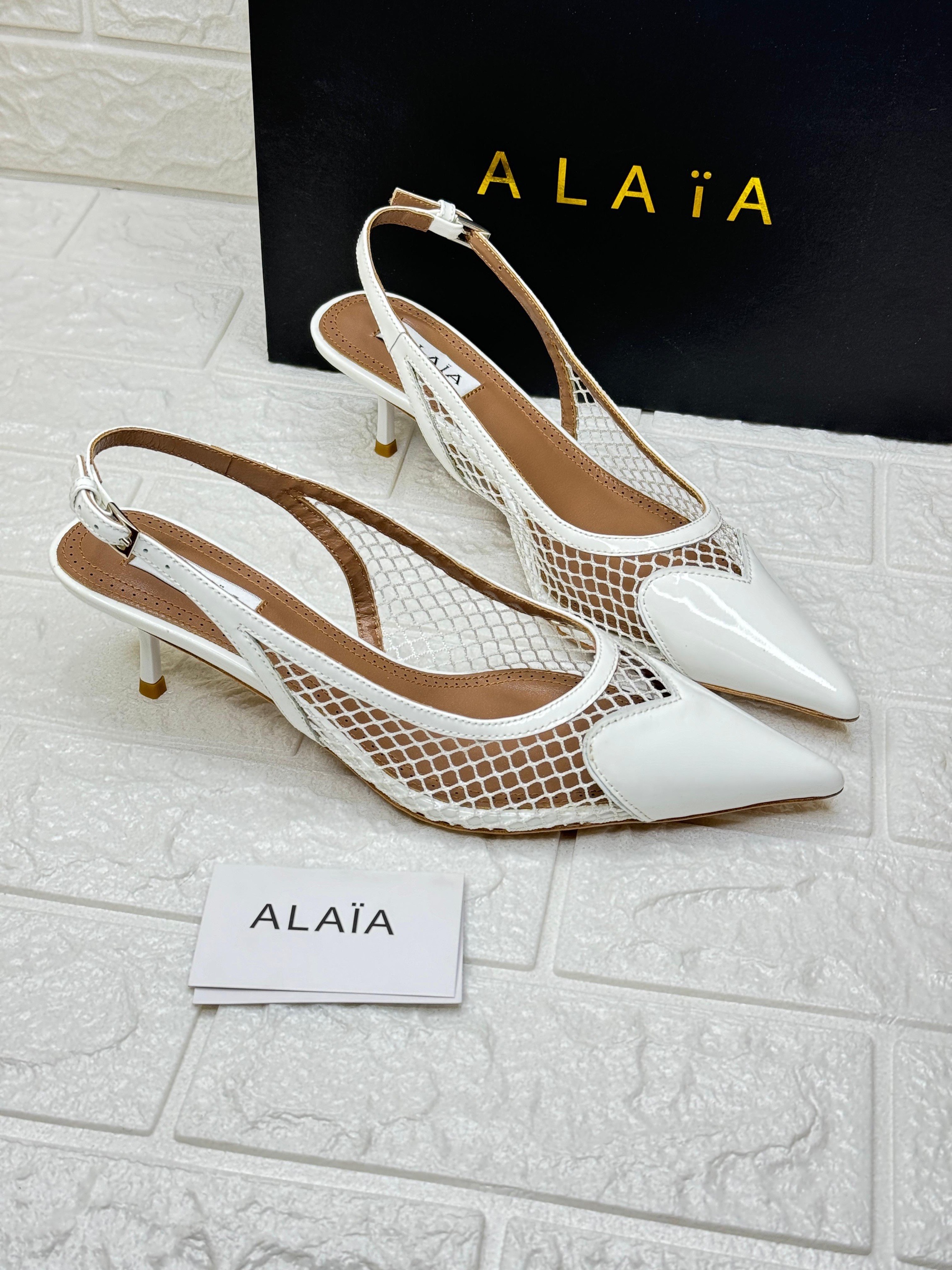 Alaïa Le Cœur slingback pumps in white (Blanc Optique) patent leather and fishnet mesh with a kitten heel. image 1