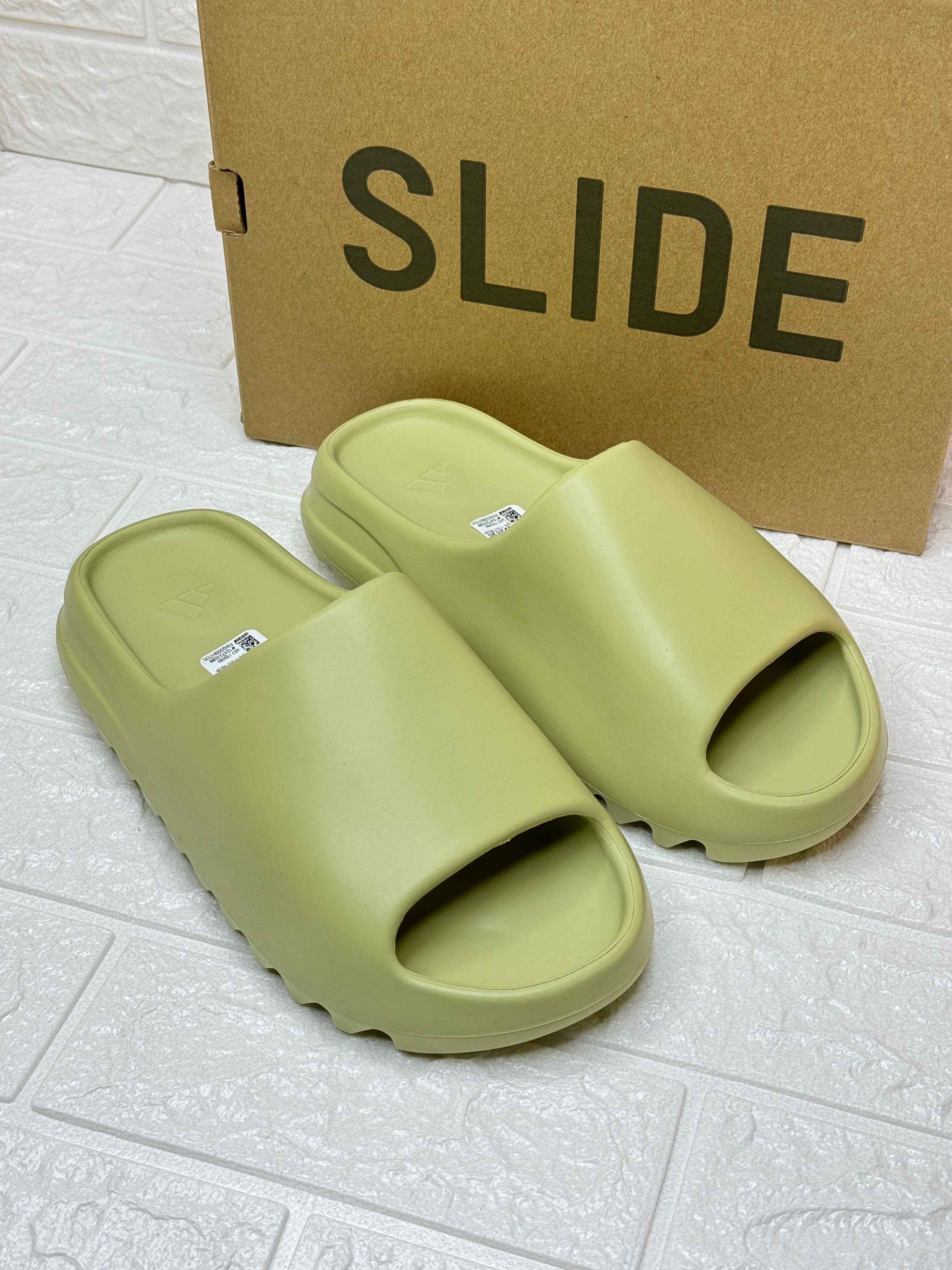 Adidas Yeezy Slide in a greenish-yellow colorway, possibly "Resin" or "Glow Green image 1