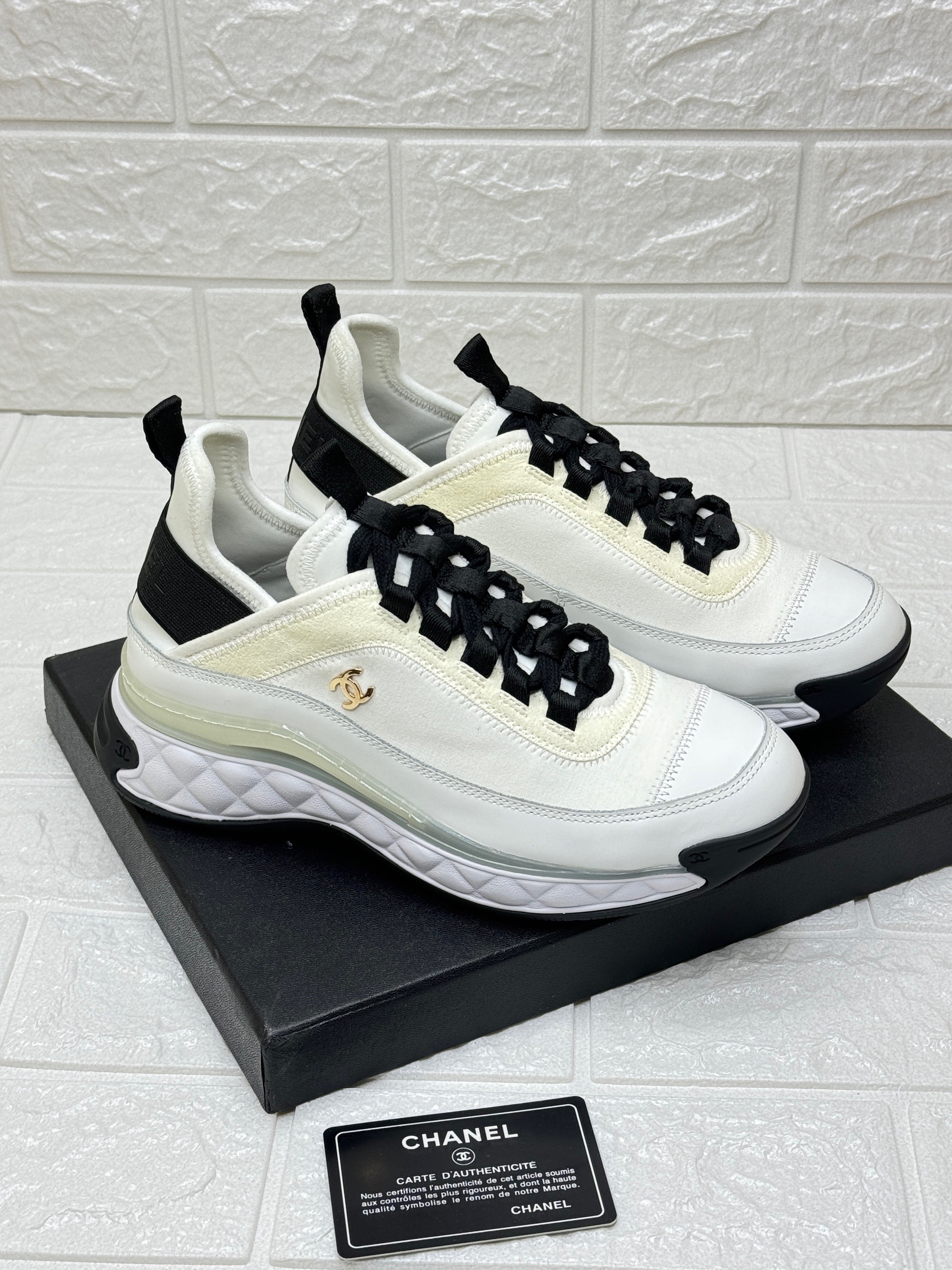 Chanel white and black low-top sneakers made from a combination of leather, neoprene, and nylon image 1