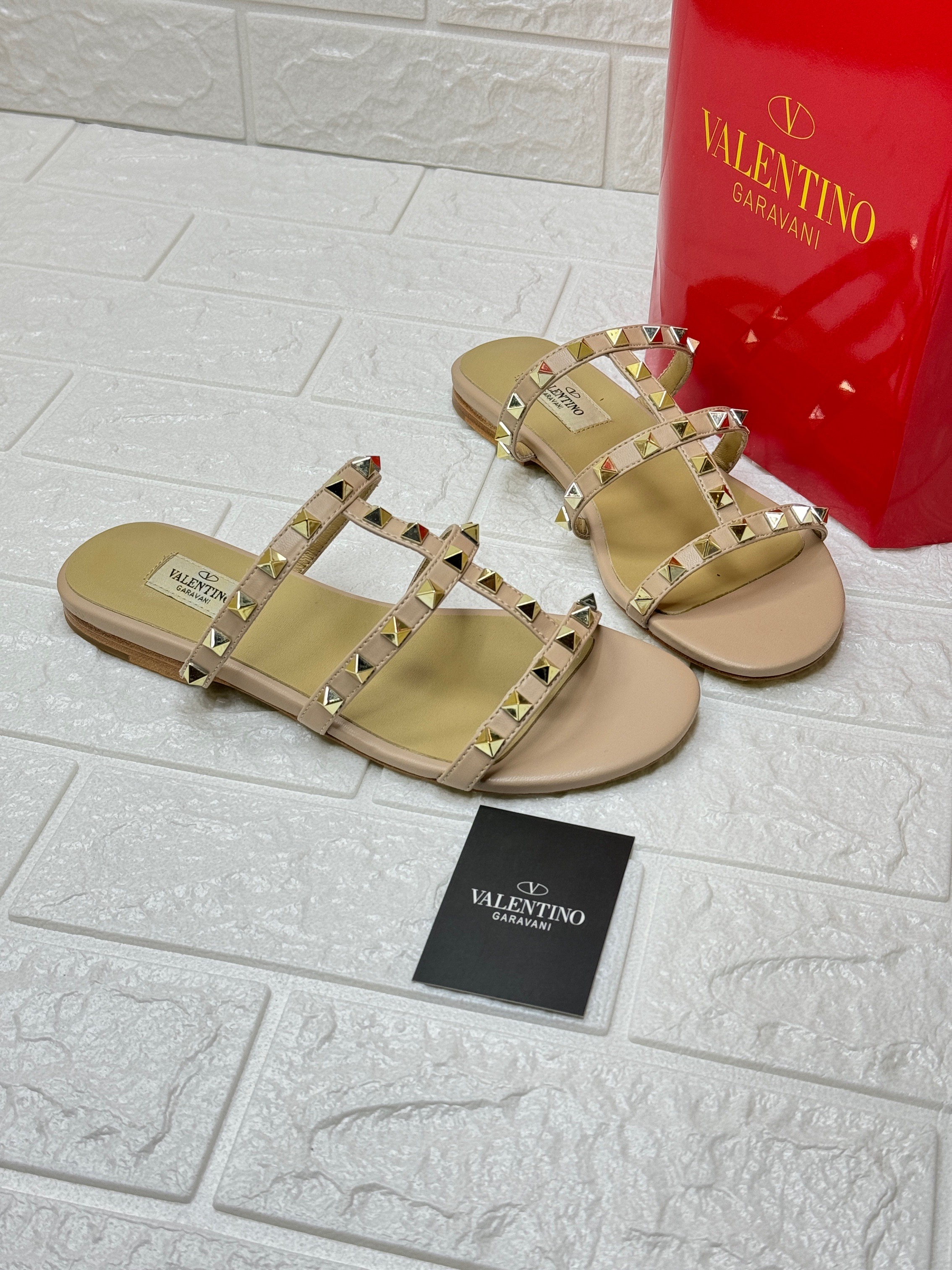Valentino Garavani Rockstud flat sandals in the color Poudre, crafted from calfskin leather with platinum-finish studs. image 1
