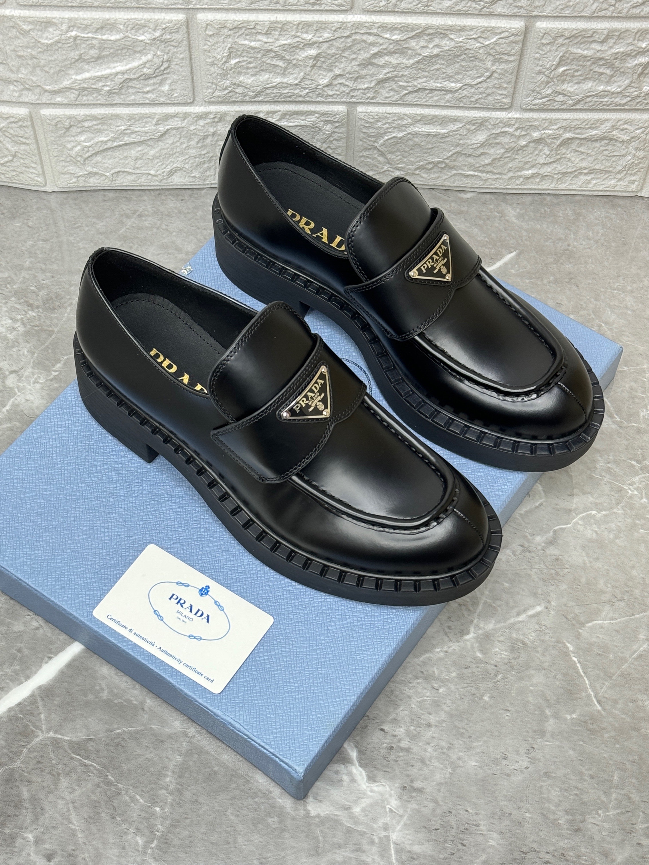 Prada brushed leather loafers with a chunky rubber sole and the iconic enamelled triangle logo. image 1