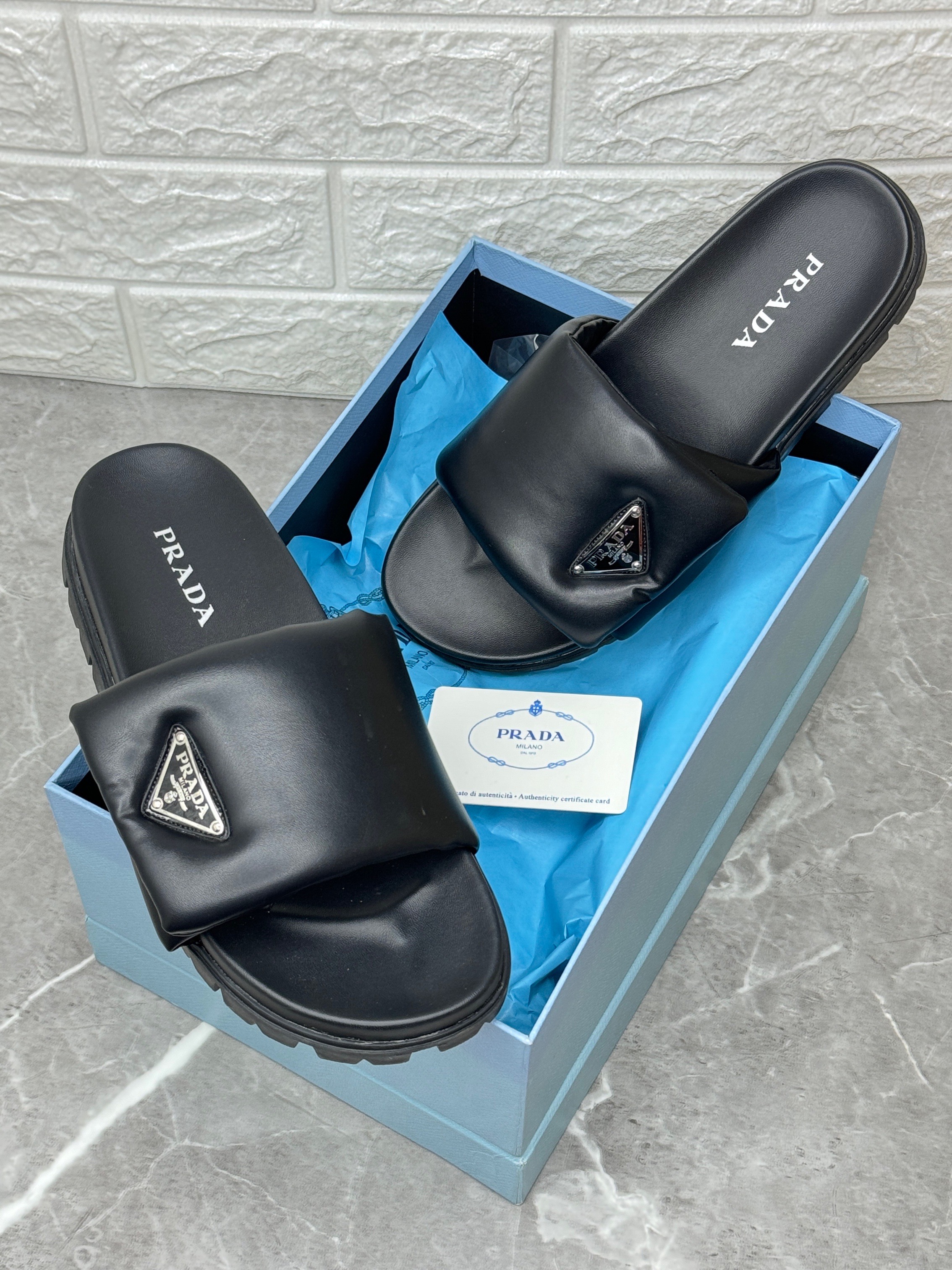 Prada padded nappa leather slide sandals featuring the iconic enameled metal triangle logo. image 1