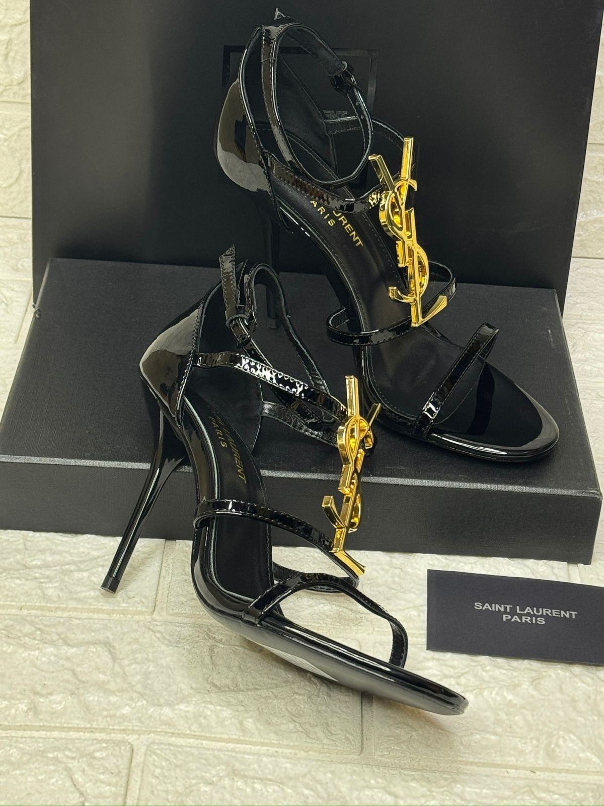 Saint Laurent Opyum sandals in black patent leather with a gold-tone Cassandre logo heel. image 1