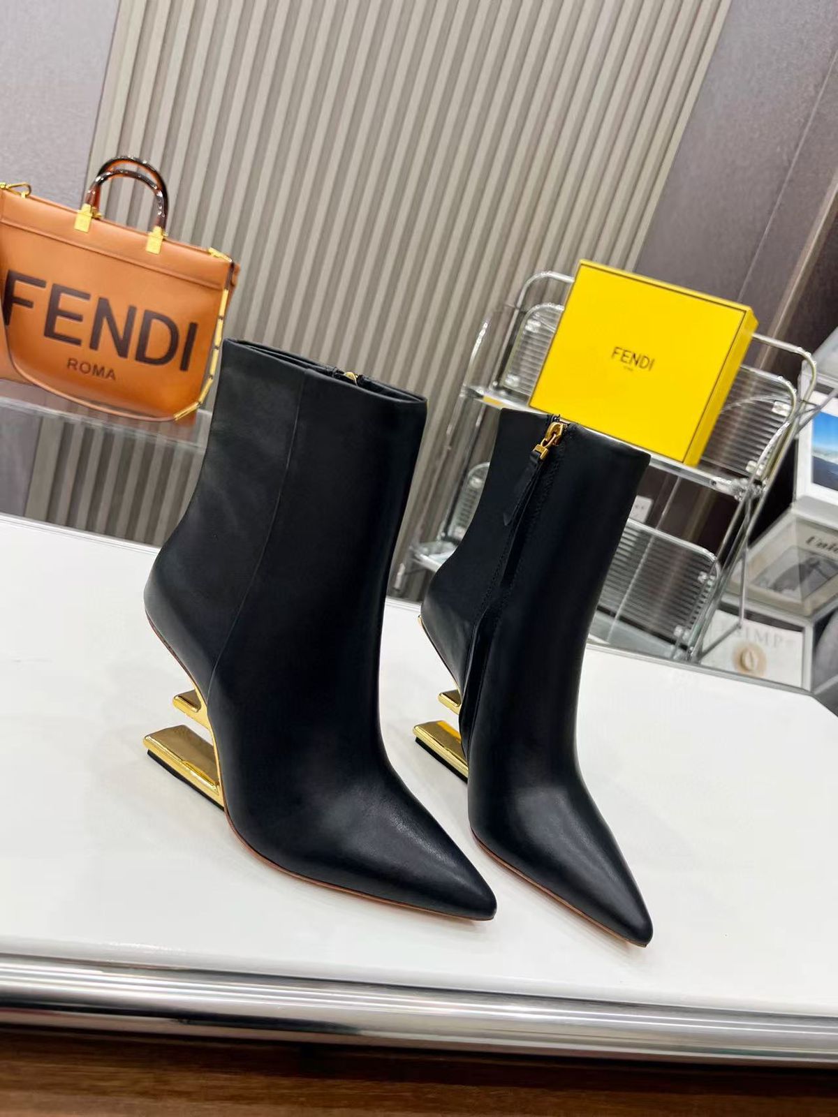 Fendi First ankle boots in black leather with a gold-tone F-shaped heel. image 1